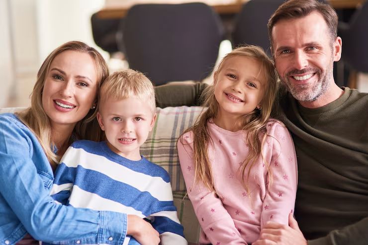 Família sorrindo no sofá de casa